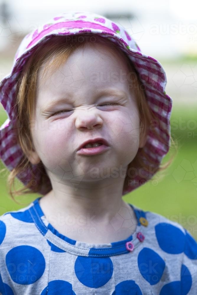 Young girl attempts a wrinkle nose smile - Australian Stock Image