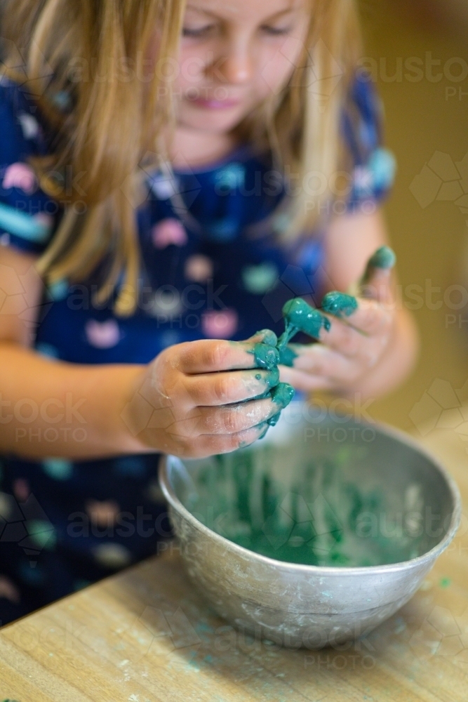 Young girl child mixing slime in a bowl - Australian Stock Image