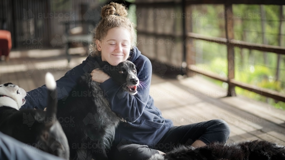 Young girl hugging her dog - Australian Stock Image