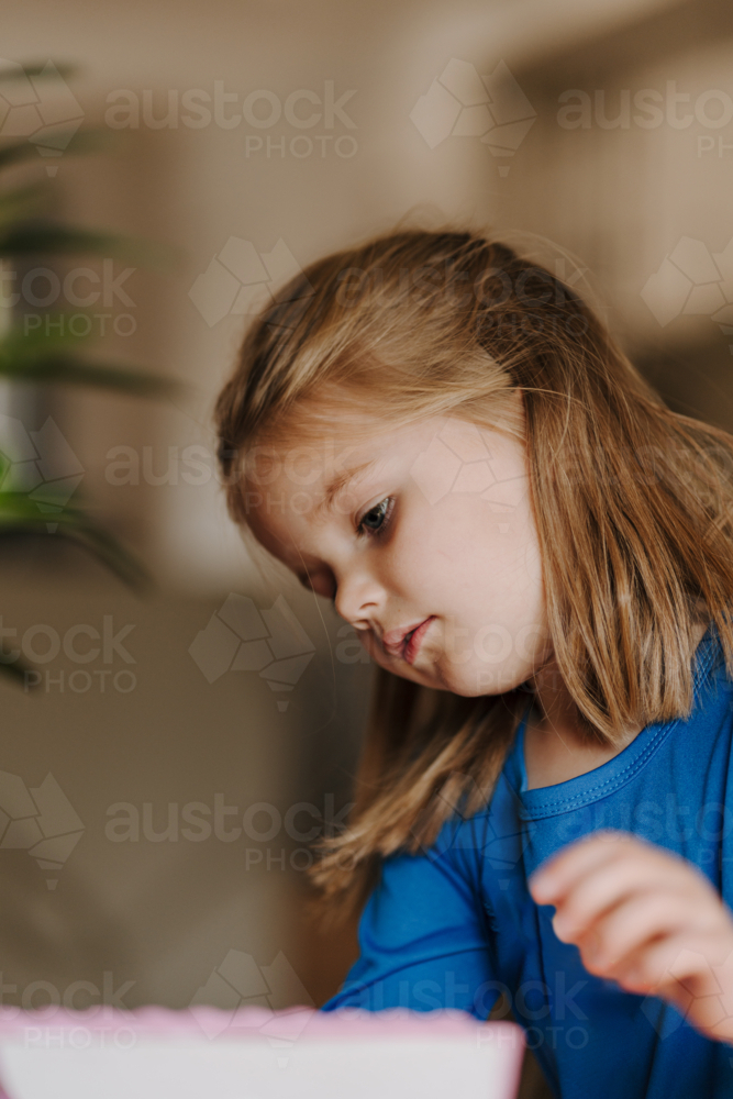 Young girl in superhero costume making an artwork. - Australian Stock Image