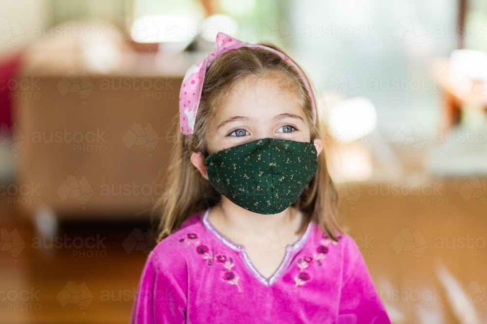 young girl inside wearing a face mask - playing dress-ups - Australian Stock Image