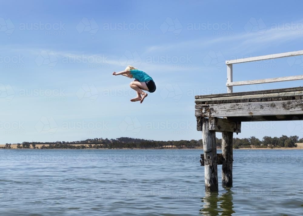 Young Girl Jumping off a Jetty - Australian Stock Image