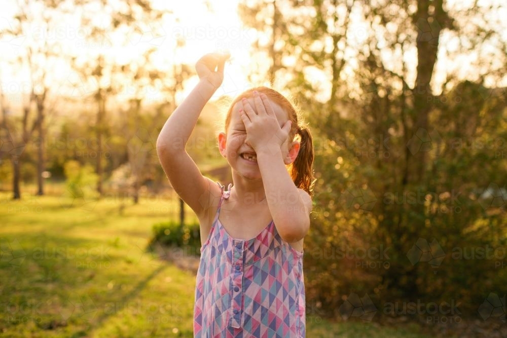 Young girl laughing in a garden - Australian Stock Image