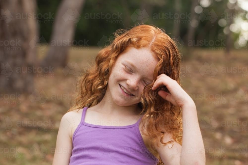 Young girl laughing in an open field - Australian Stock Image