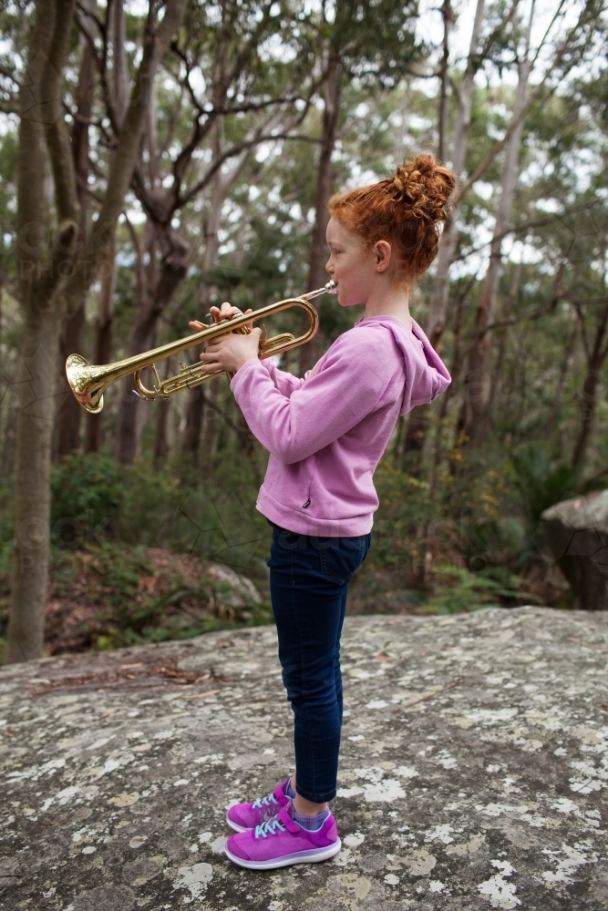 Young girl playing a trumpet outside - Australian Stock Image