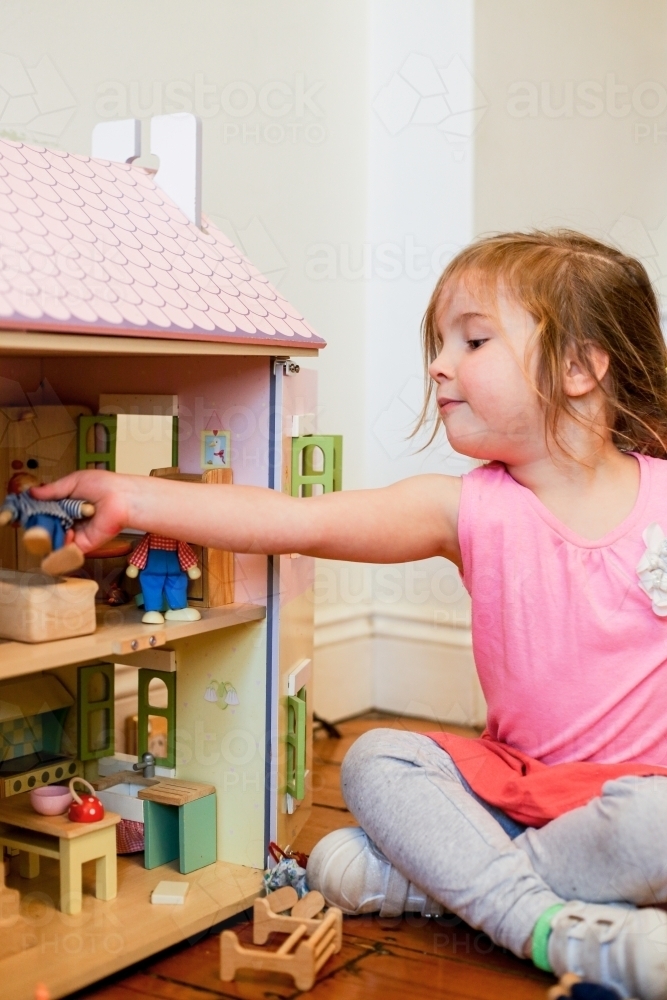 Young girl playing with a dollhouse - Australian Stock Image