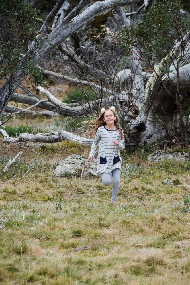 Young girl runs in the country side. - Australian Stock Image