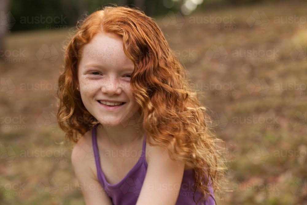 Young girl smiling in an open field - Australian Stock Image