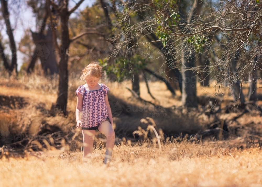 Young girls in dry grassy summer field - Australian Stock Image