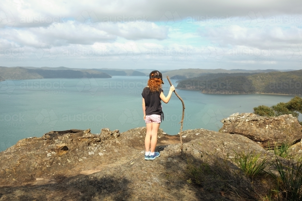 Young girls standing on a rock looking at the view - Australian Stock Image