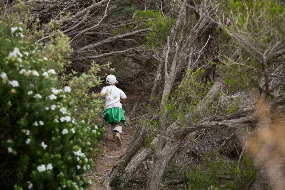 Young kid running through trees in bush - Australian Stock Image