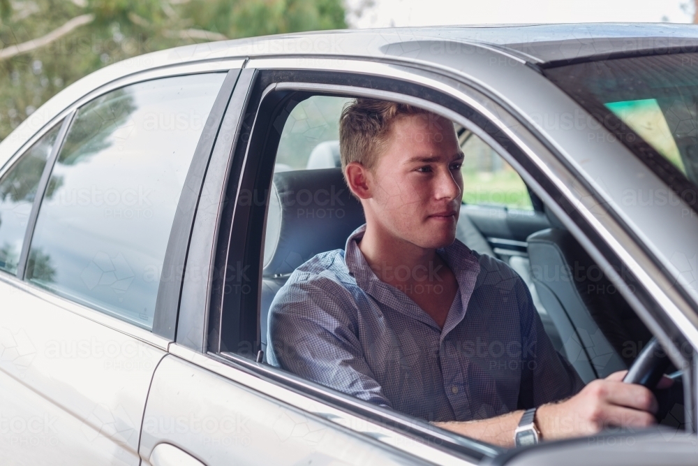 Image of young man in a car - Austockphoto