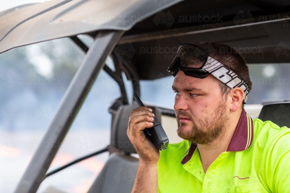 Young man talking on walkie-talkie two way radio - Australian Stock Image