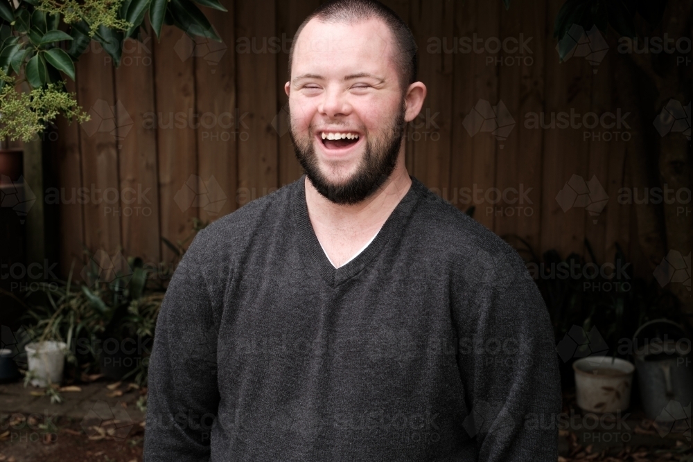 Young Man with Down Syndrome Laughing Heartily - Australian Stock Image