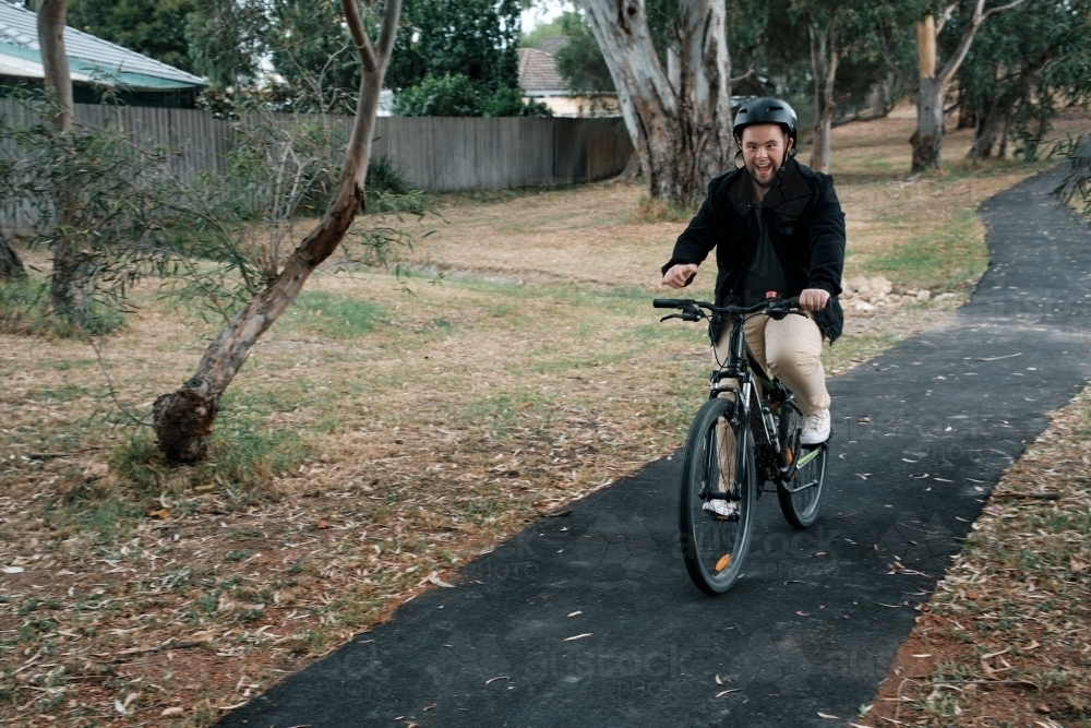 Young Man with Down Syndrome Riding a Bike - Australian Stock Image