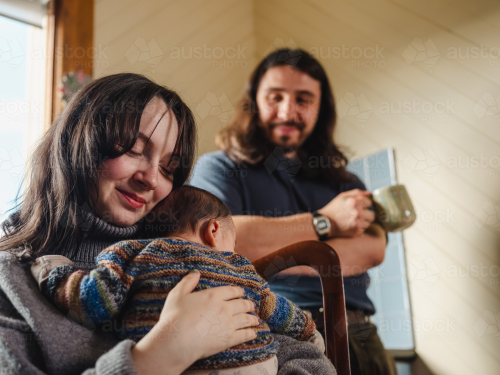 Young mother holding baby dressed in striped sweater - Australian Stock Image