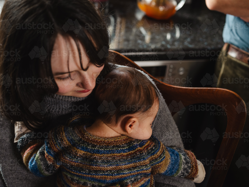 Young mother holding baby dressed in striped sweater - Australian Stock Image