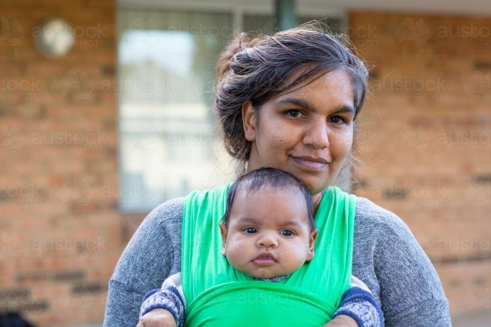 Young mother wearing her baby in a wrap - Australian Stock Image