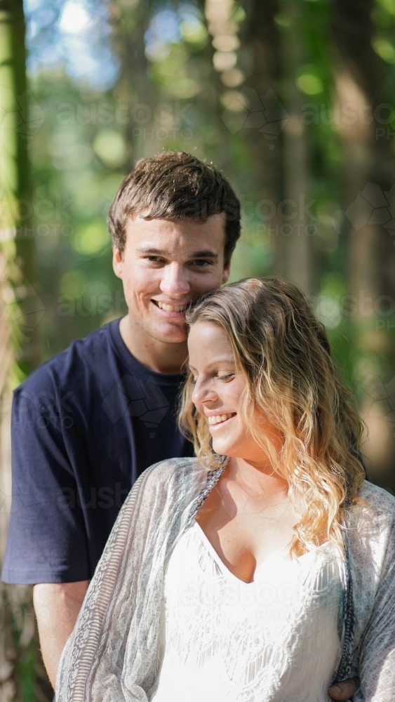 Young pregnant couple embracing, half shot - Australian Stock Image