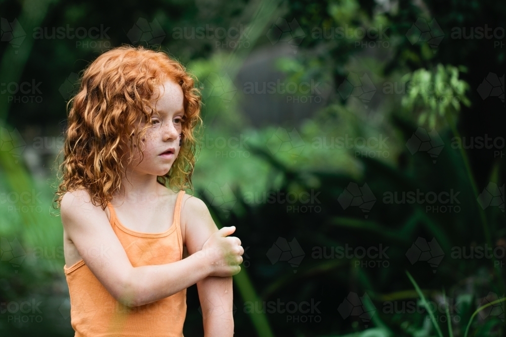 Young redhead girl in an orange singlet - Australian Stock Image