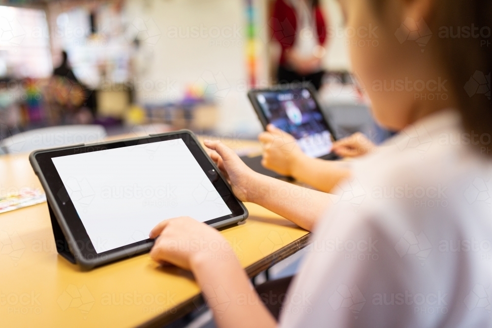 Young students using iPads in classroom - Australian Stock Image