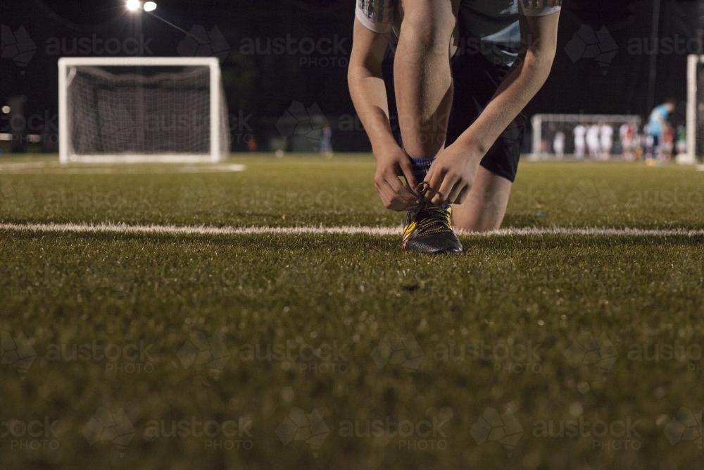 Young teen boy preparing to do evening soccer training - Australian Stock Image