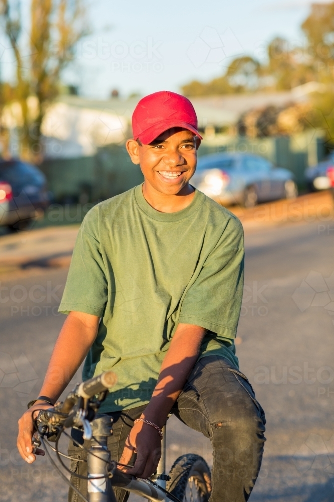 young teen sitting on bike in street - Australian Stock Image