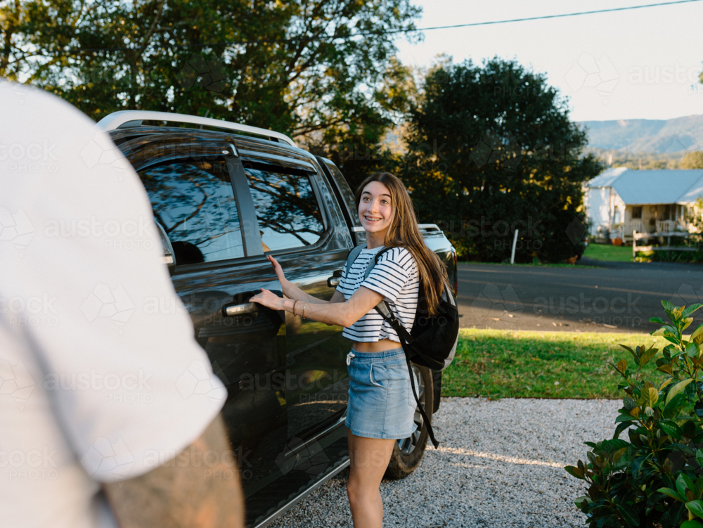 Young teenage girl opening the car door. - Australian Stock Image