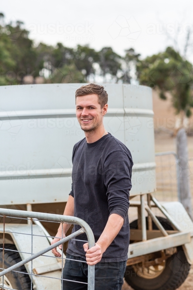 Young tourist opening a gate on a farm - Australian Stock Image