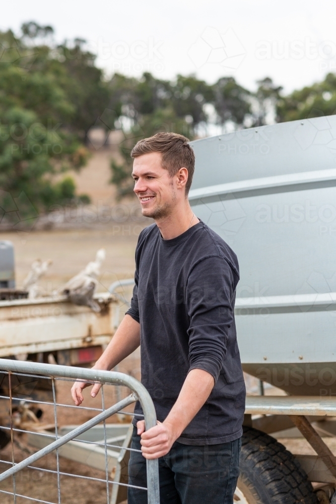 Young tourist opening a gate on a farm - Australian Stock Image