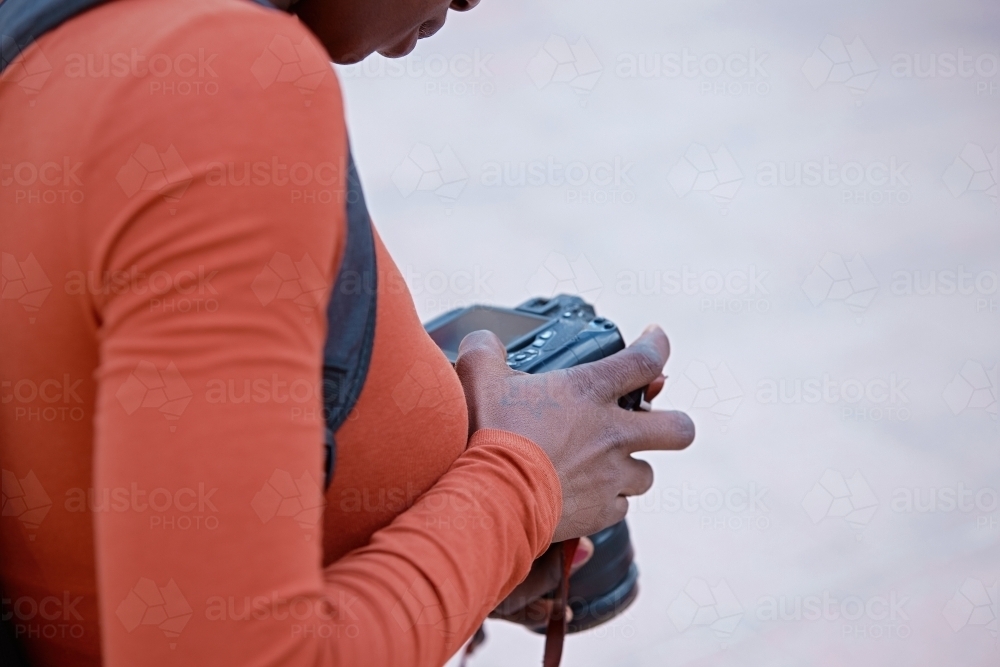 Young woman checking back of digital camera - Australian Stock Image