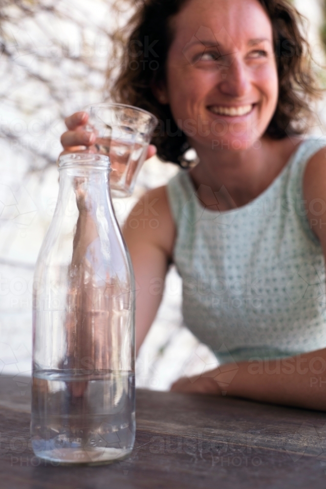 Young woman drinking water while looking away from camera - Australian Stock Image