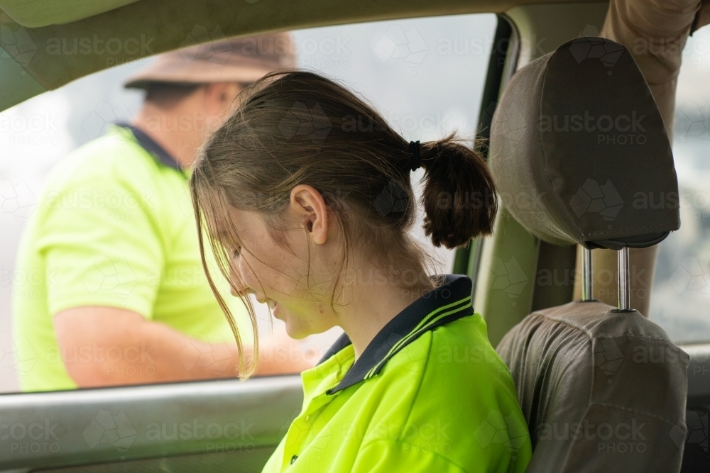 Young woman in vehicle wearing hi-vis - Australian Stock Image