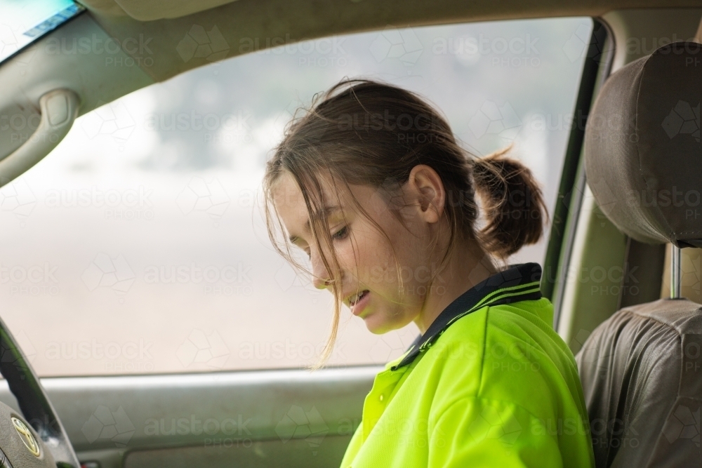 Young woman in vehicle wearing hi-vis - Australian Stock Image