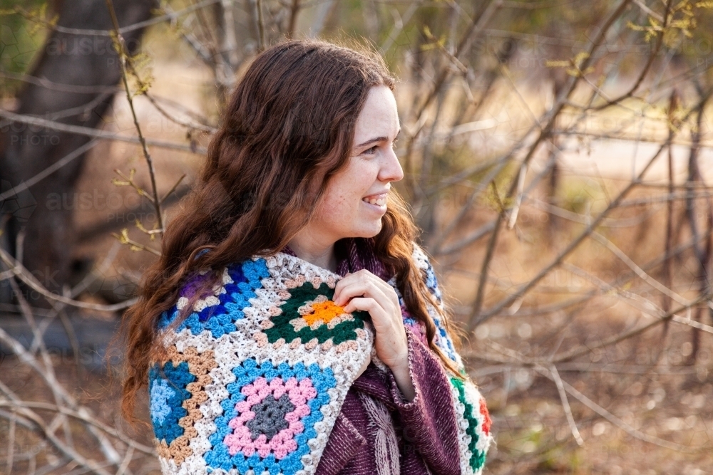 Young woman in winter scenery with crochet blanket and woolen jumper - Australian Stock Image