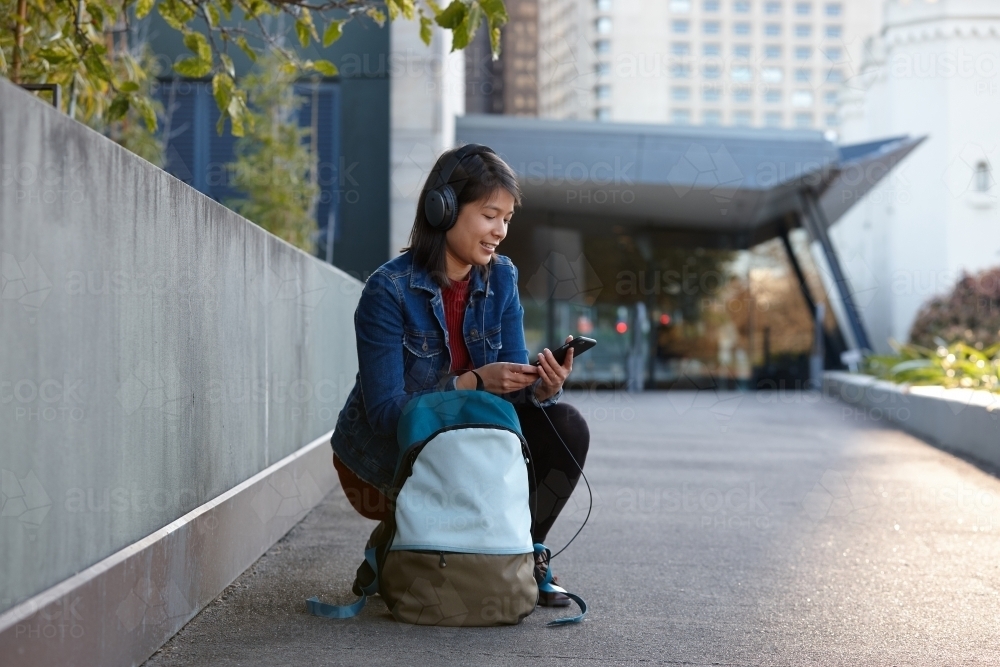 Young woman listening to music on phone - Australian Stock Image