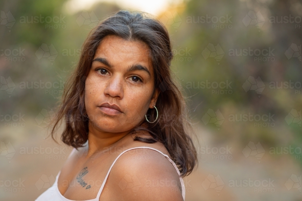 young woman looking at camera with blurry background - Australian Stock Image