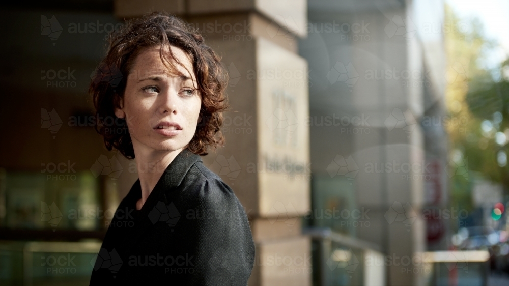 Young woman looking over shoulder in the city - Australian Stock Image