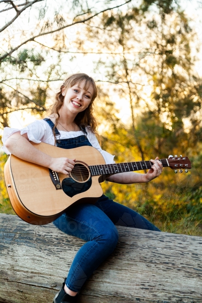 Young woman sitting on long playing instrument - Australian Stock Image