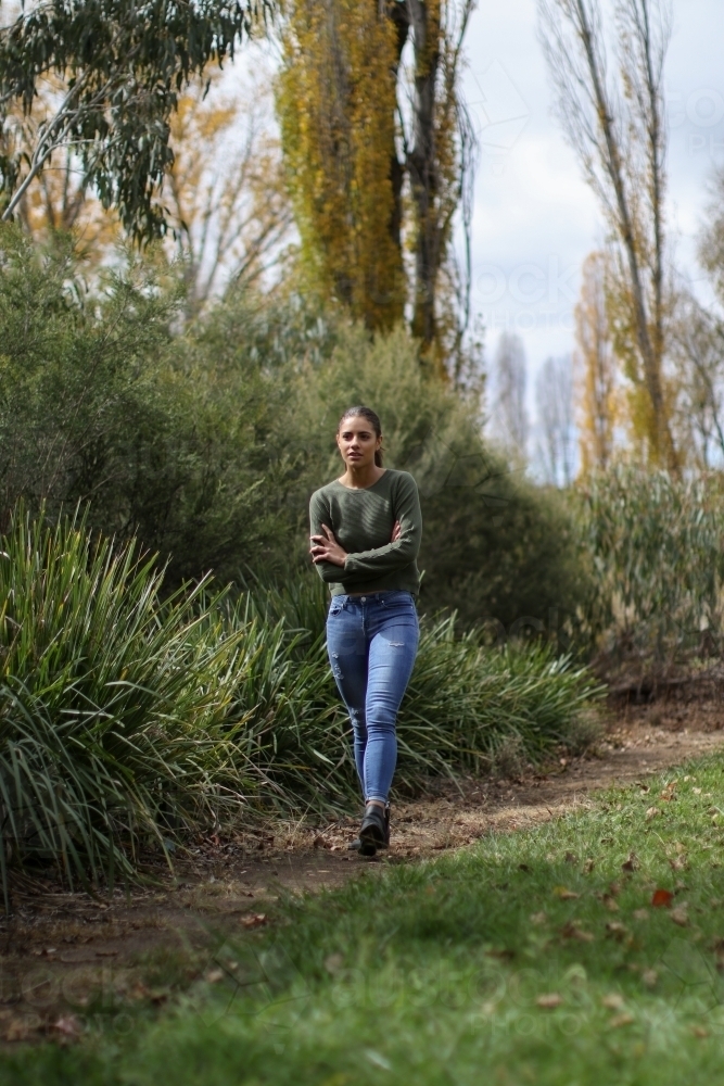 Young woman walking alone in the park - Australian Stock Image