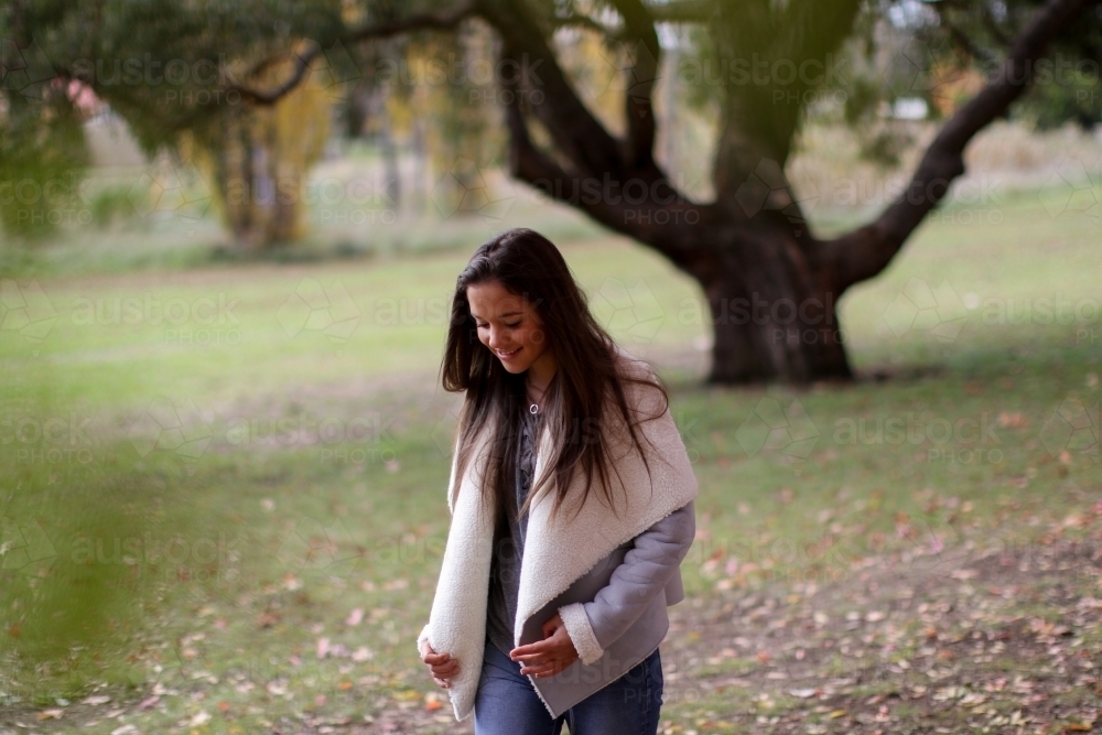 Young woman walking alone in the park - Australian Stock Image