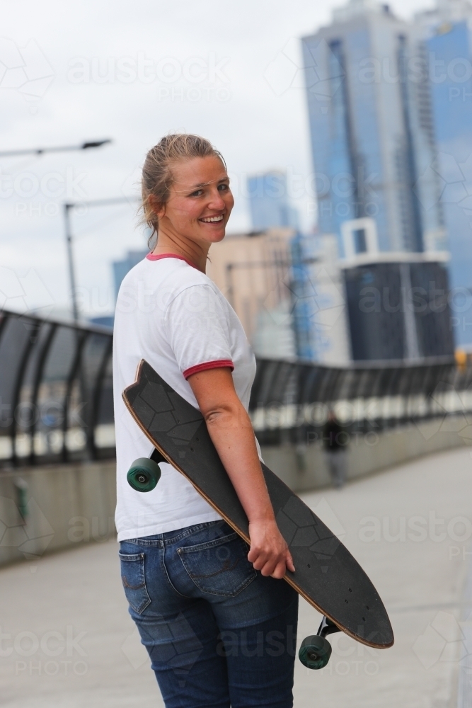 Young Woman Walking with Her Skateboard - Australian Stock Image