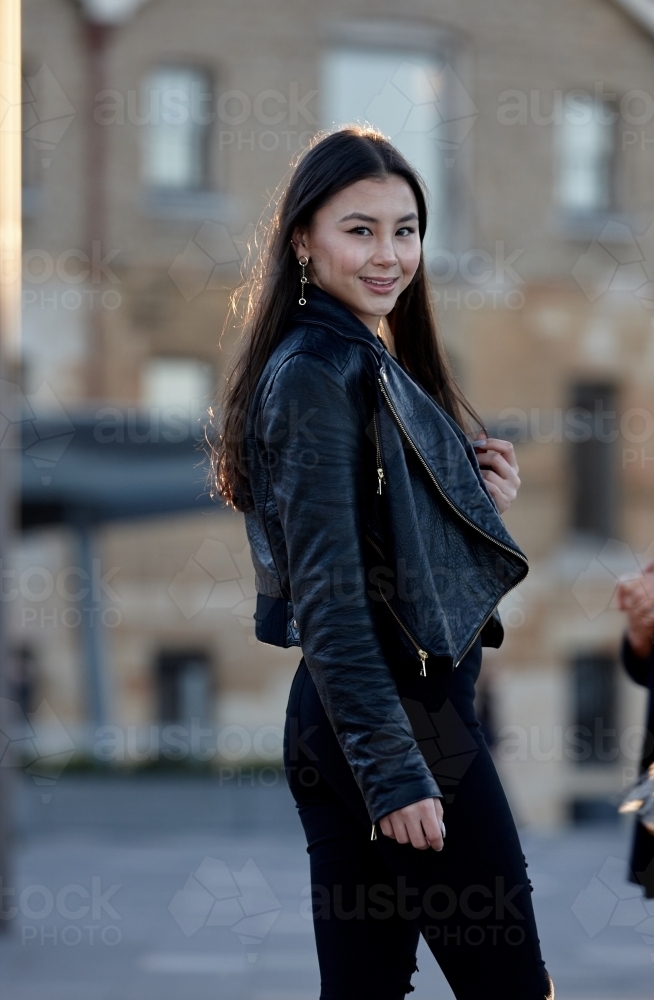 Young woman wearing leather jacket - Australian Stock Image