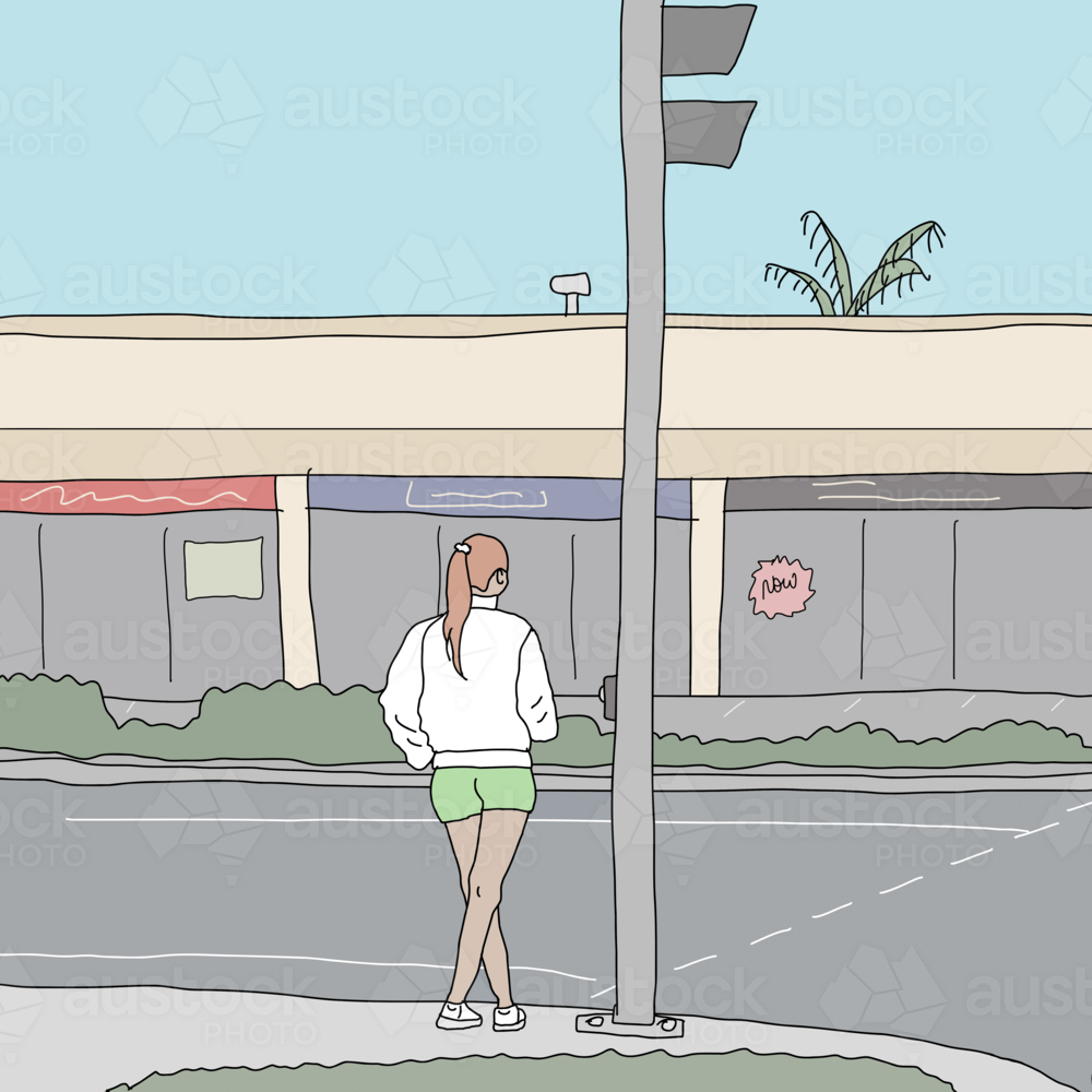 Young woman wearing shorts, sweater and joggers waiting to cross the road - Australian Stock Image