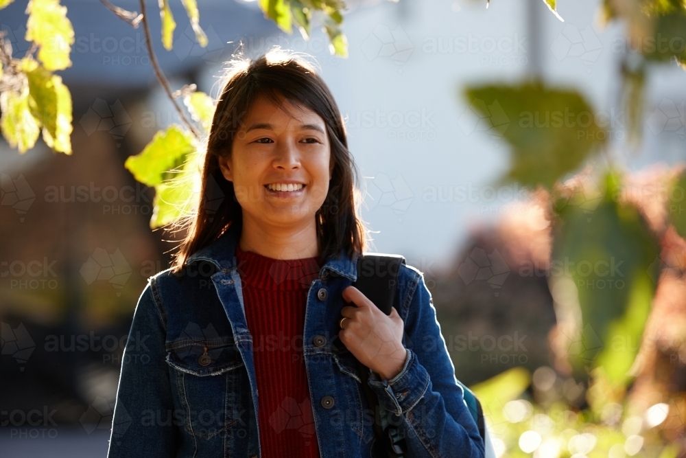 Young woman with backpack in sun - Australian Stock Image