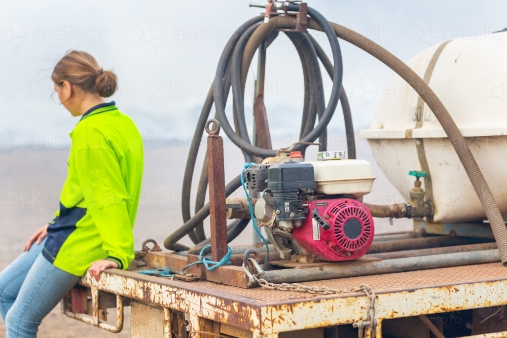 Young woman with fire-fighting equipment on farm - Australian Stock Image