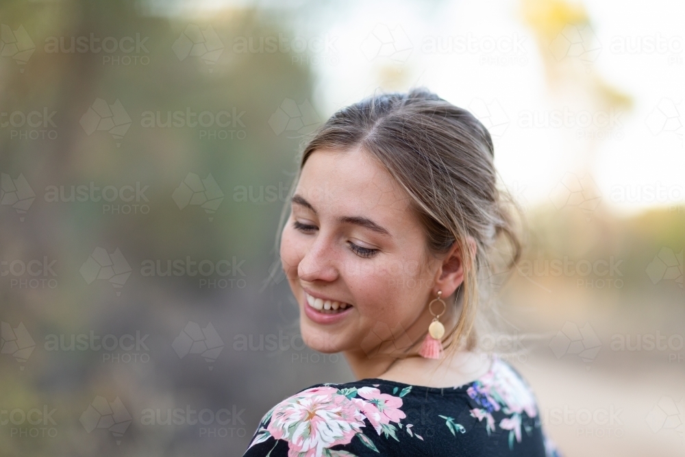 young woman with head turned looking down - Australian Stock Image