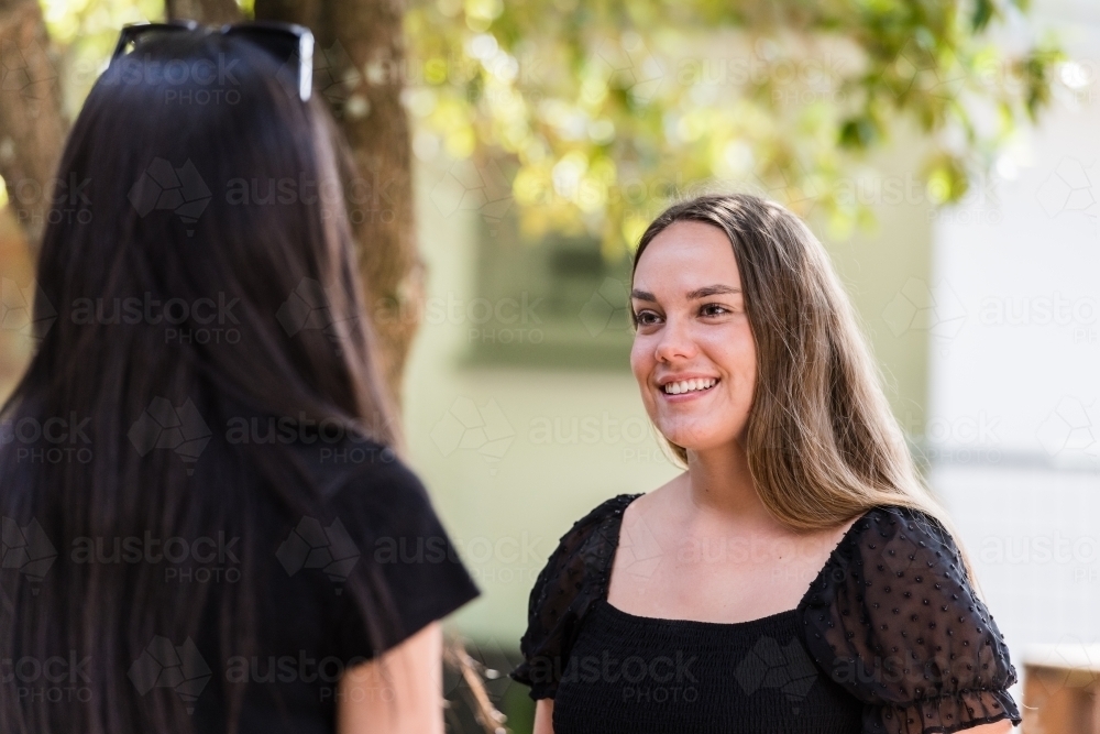 young women talking outside - Australian Stock Image