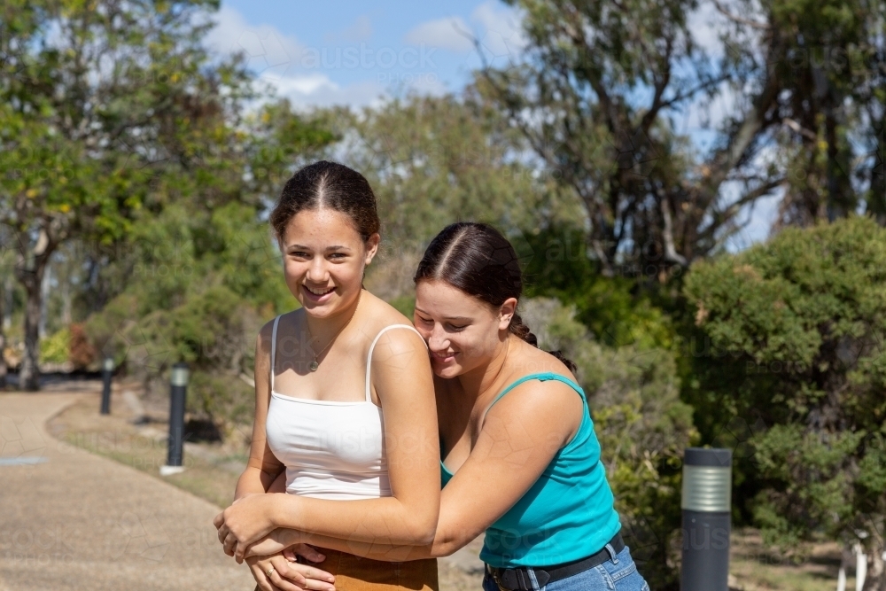 young women with arms around each other outdoors - Australian Stock Image