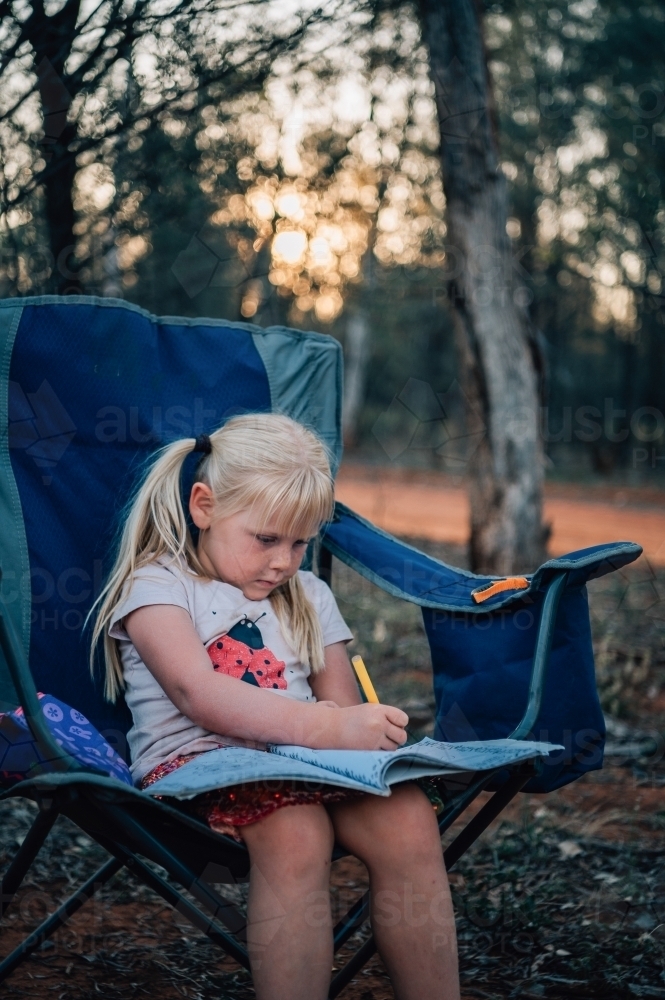 Your girl journaling while camping outdoors - Australian Stock Image